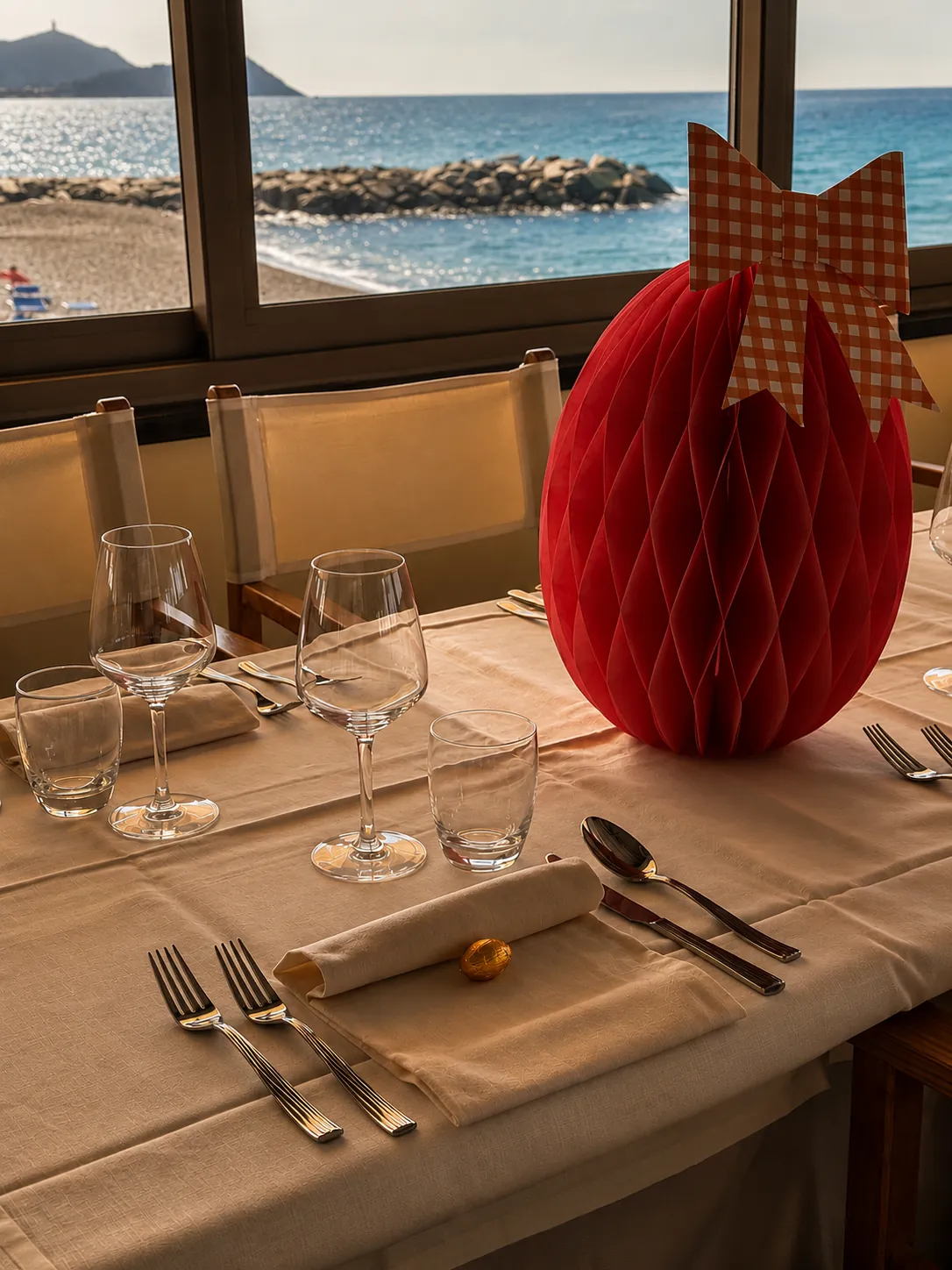 Mise en place elegante con decorazione rossa e vista mare