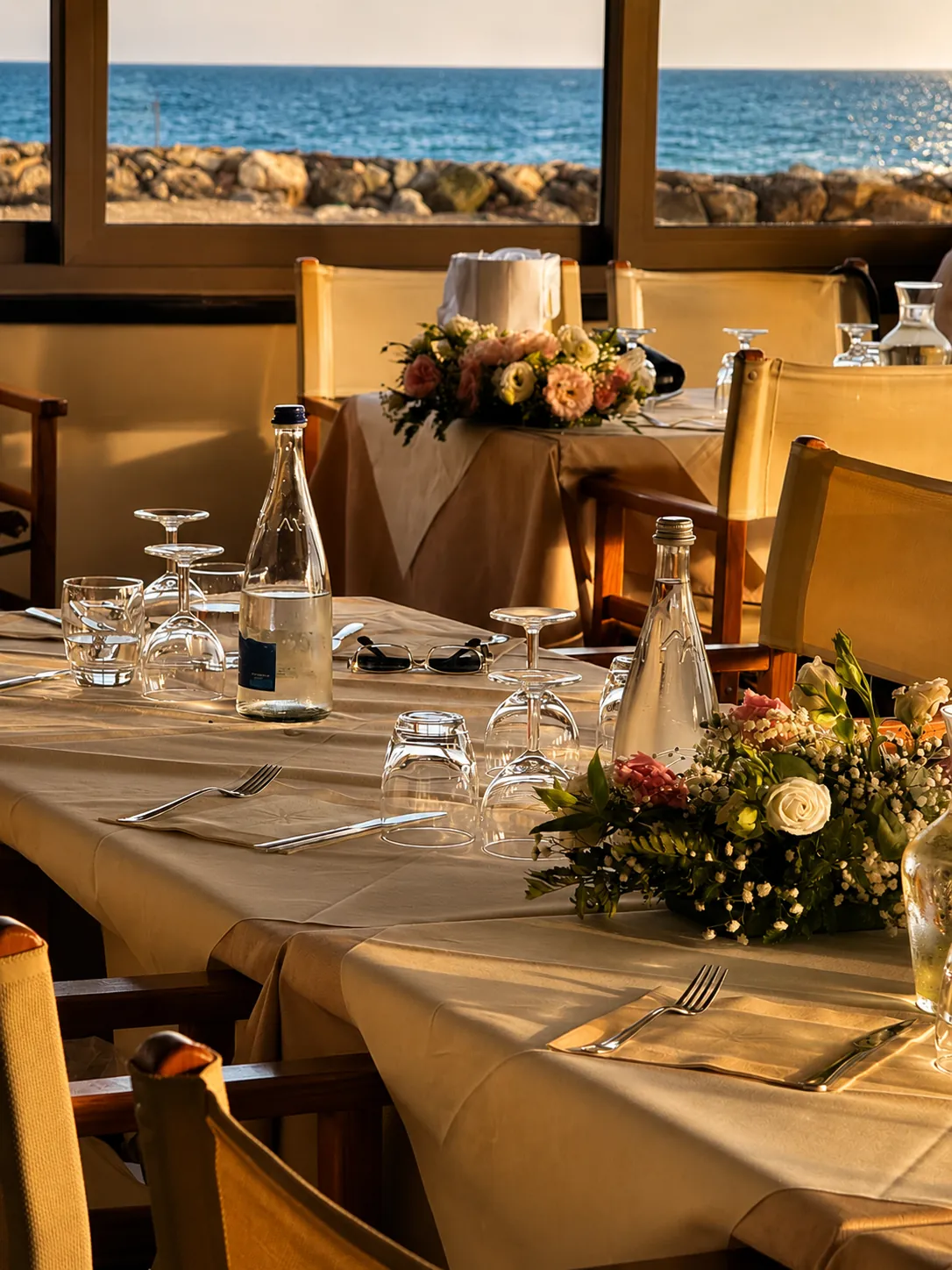 Tavoli con fiori e vista mare per evento al tramonto