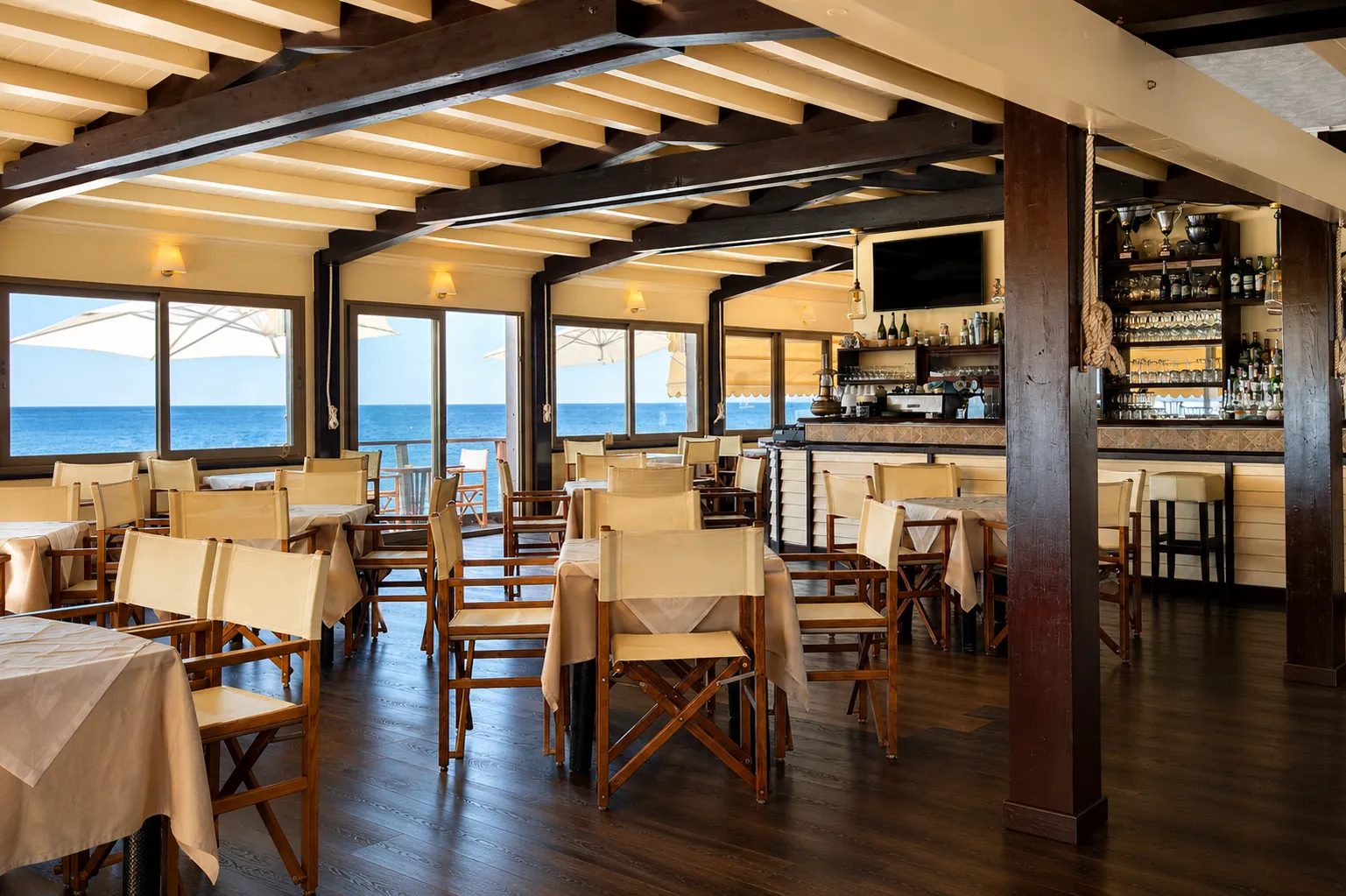 Sala ristorante Bagni Serenella con tavoli vista mare
