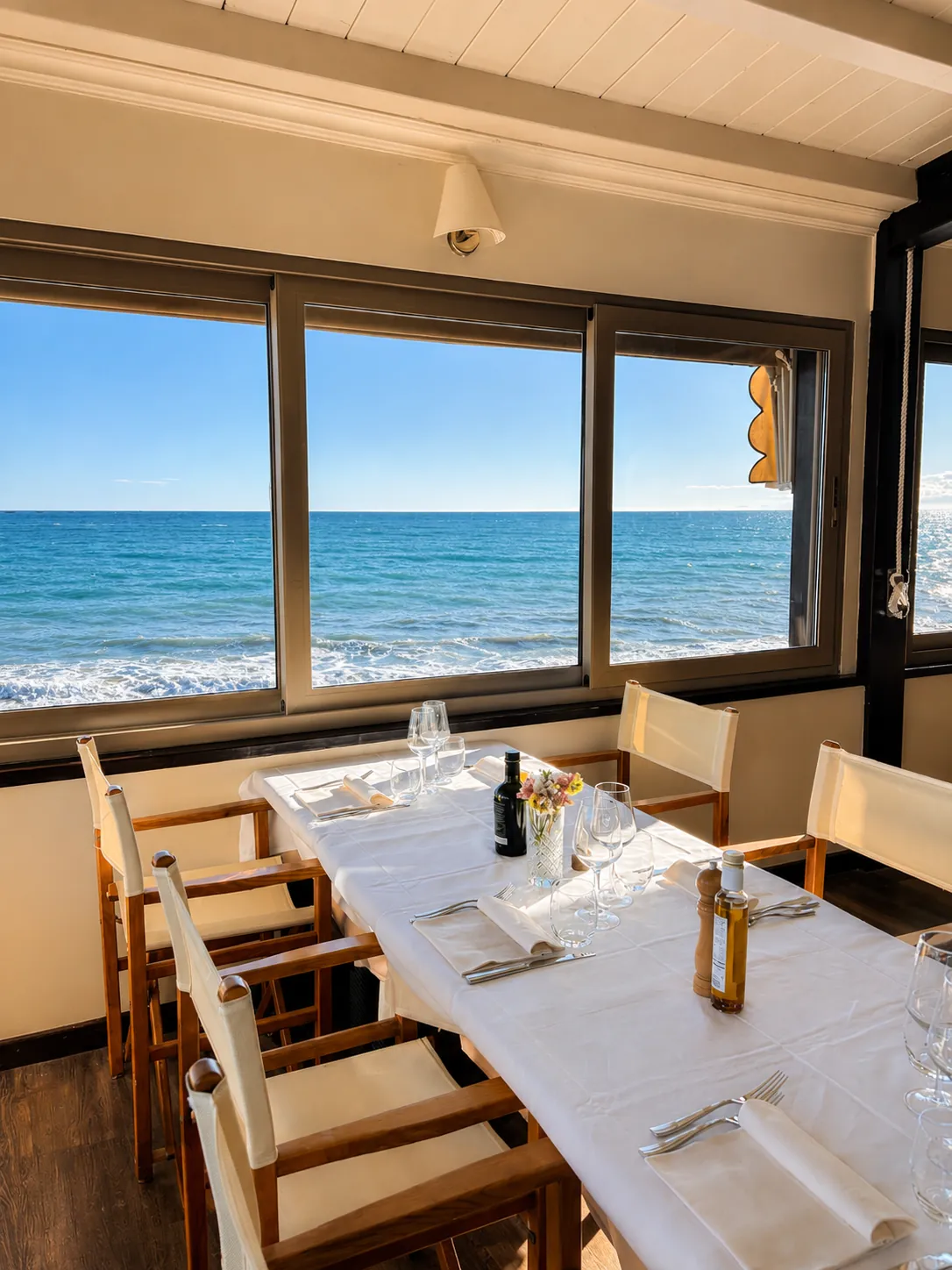 Tavolo apparecchiato vicino alle finestre con vista mare