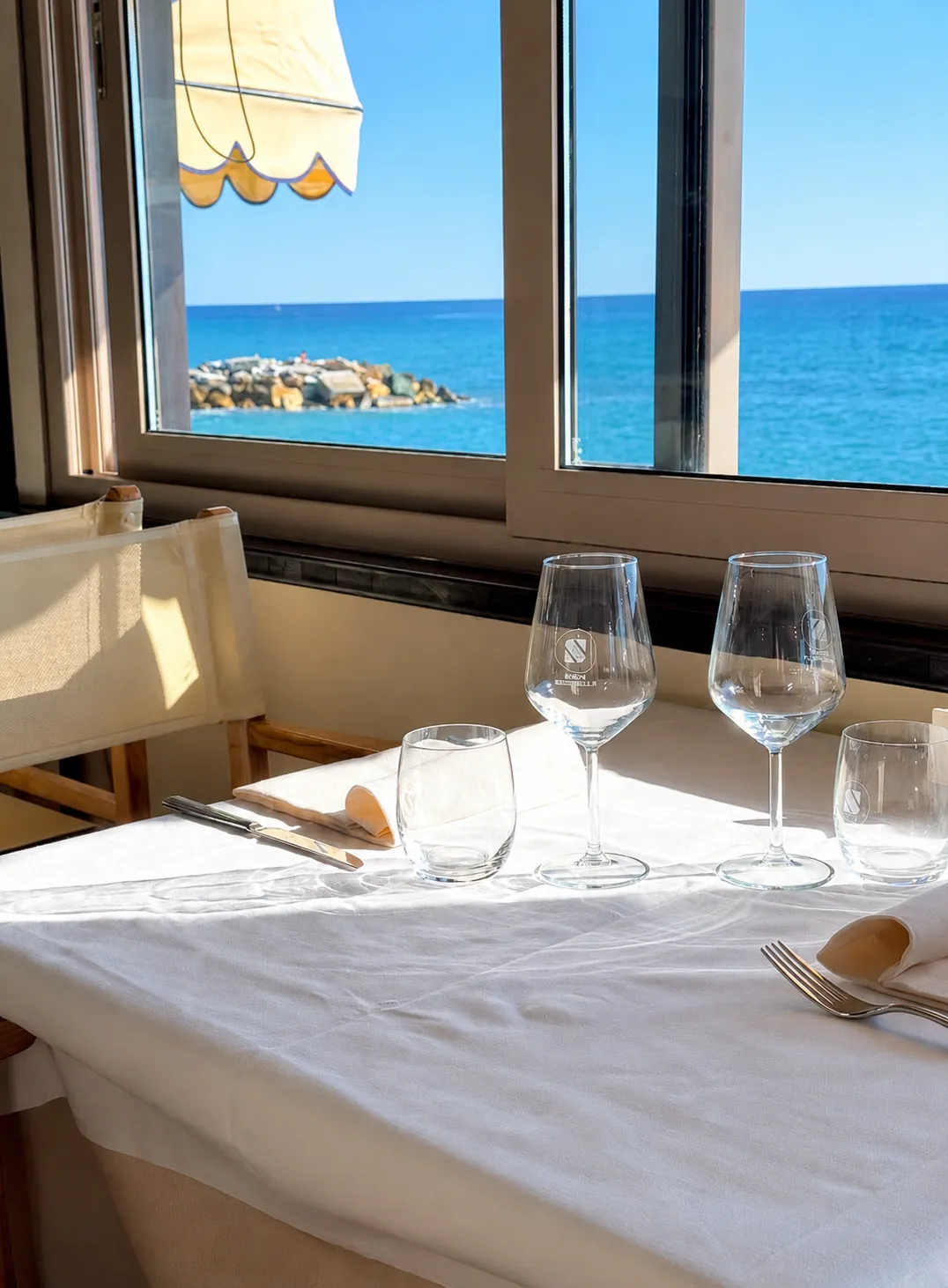 Tavolo apparecchiato con vista mare al ristorante Bagni Serenella